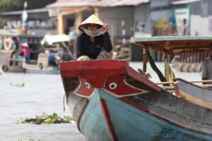 femme sur un bateau traditionnel dans le delta du Mékong